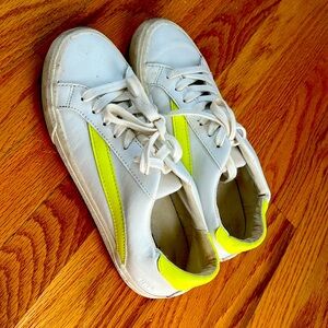 Madewell white sneakers with neon yellow detail.